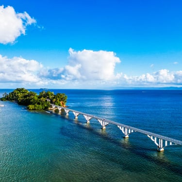 Samaná bridge over blue ocean with sailboats and tropical island in Dominican Republic