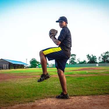 Young Dominican baseball player practicing on a local baseball field in the Dominican Republic