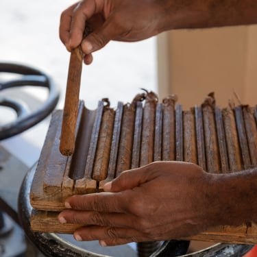 Hand-rolling premium Dominican cigars using a traditional wooden cigar mold in a local factory