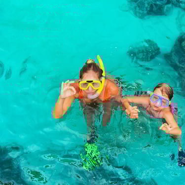 Mother and child snorkeling in crystal-clear waters at Catalina Island