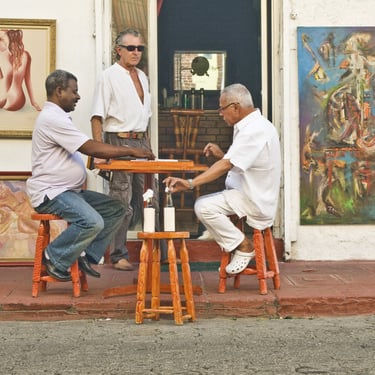 Men playing dominoes outside an art gallery in Santo Domingo Dominican Republic enjoying local culture