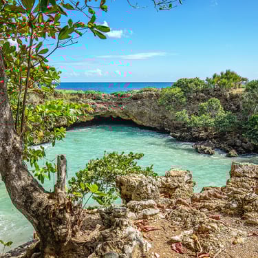 Hoyo Zumbador natural pool in Boca de Yuma with a rock arch opening to the Caribbean Sea, Dominican Republic