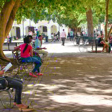 People relaxing in a shaded plaza in Santo Domingo Dominican Republic enjoying local culture and daily life