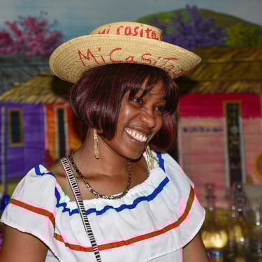 Smiling Dominican woman in traditional dress during a cultural experience in the Dominican Republic