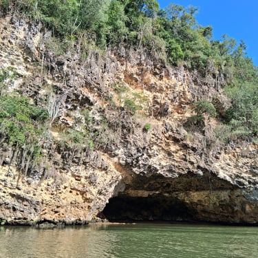 Cofresí’s Cave entrance along the Yuma River surrounded by rocky cliffs and greenery in Boca de Yuma, Dominican Republic