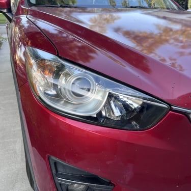 Clear headlight on red car. Restored and looks new