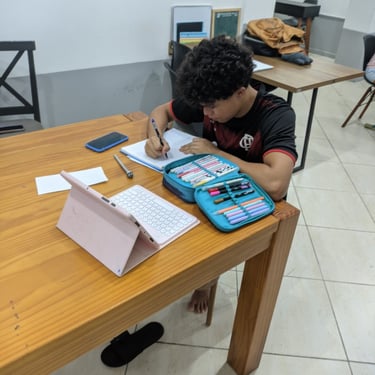 a boy is sitting at a table with a calculator