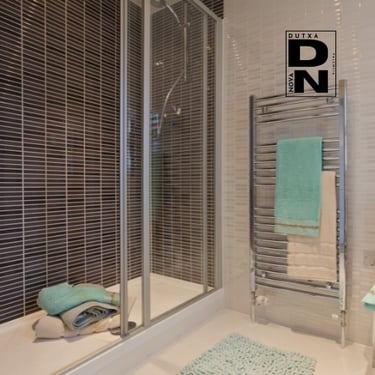 Ducha con mampara de cristal y azulejos decorativos oscuros, estilo elegante y moderno en baño reformado por Dutxa Nova en Va