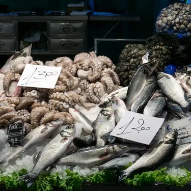 Fresh seafood displayed at the Rialto fish market in Venice, featuring octopus, sea bass, and shellfish – the heart of local 