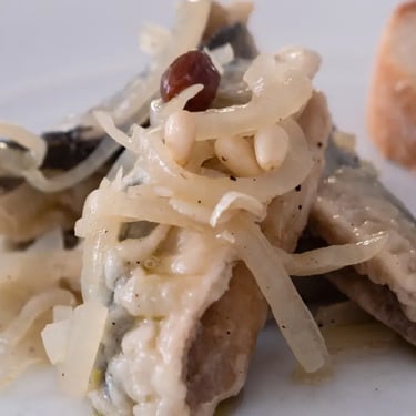 Traditional sarde in saor dish, a Venetian sweet-and-sour sardine specialty served with onions, pine nuts, and raisins – auth