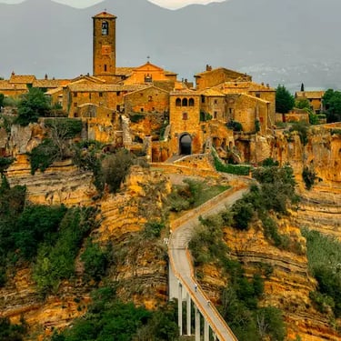 Civita di Bagnoregio, the ‘Dying City’, perched on a cliff in Lazio, Italy, connected to the mainland by a scenic bridge.”