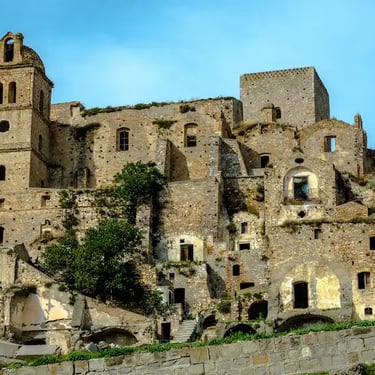Historic ruins of Craco ghost town on a steep hill in Basilicata, Italy, with ancient stone houses and church tower