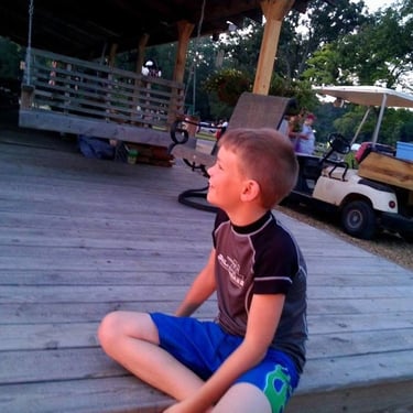 boy sitting on outdoor deck 