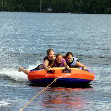 Kids riding a tube in lake
