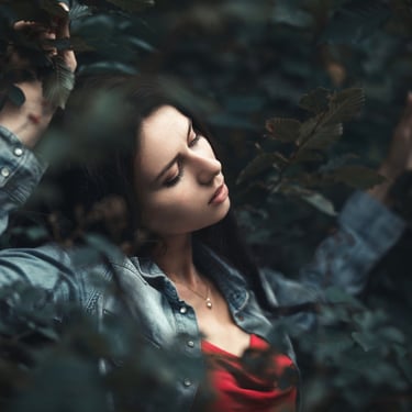 Portrait serré d'une femme de profil dans les branches d'un arbre 