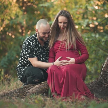 Couple futurs parents assis a coté d'un arbre