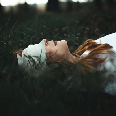 Femme allongée dans les herbes hautes