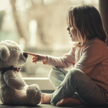 Petite fille qui joue avec son ourson