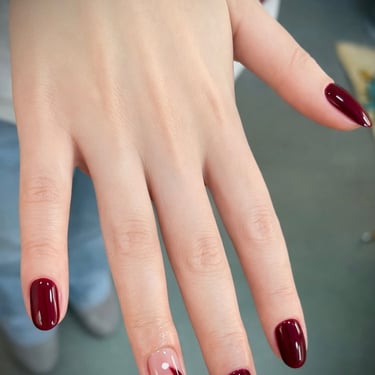 Uñas color vino tinto con diseño abstracto minimalista en blanco y rojo en el dedo anular. Elegancia  en Glamour Beauty Salon