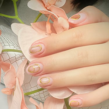 Manicura con diseño de nail art minimalista y detalles en líneas doradas, especialidad de nuestras artistas en Calle Baleares