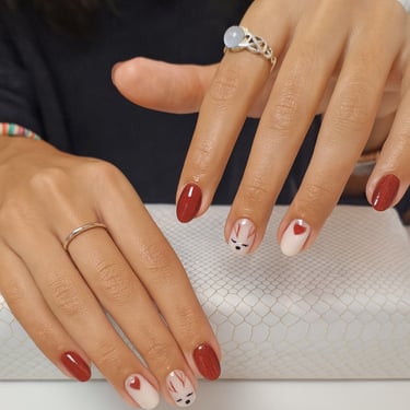 Manicura de Navidad  con reno pintado a mano, detalle de corazón y esmalte rojo con glitter. Arte en uñas para fiestas