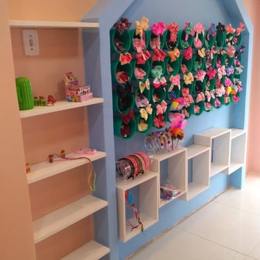 imagem de uma loja com decoração infantil contendo nichos e prateleiras na cor branca