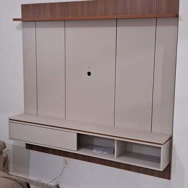 imagem de um painel de tv bege com partes amadeiradas