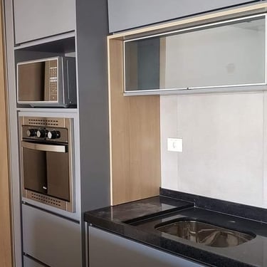 imagem de móveis planejados de uma cozinha predominantemente cinza com eletrodomesticos e balcão preto