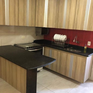 imagem de móveis de cozinha planejados predominantemente amadeirados com puxadores de alumínio prata