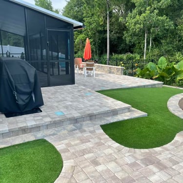 a patio with a walkway and a BBQ grill