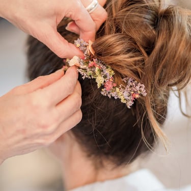 Nadine Raimbault mettant des fleurs dans les cheveux d'une mariée