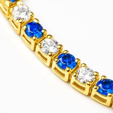 a gold bracelet with blue and white diamonds