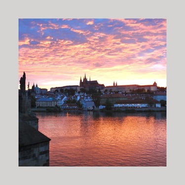 Strahlender, oranger Sonnenuntergang über der Prager Burg, als Logo für Mystiker Stadtbummel