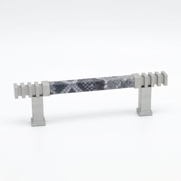 Photography case study featuring a cabinet pull with a leather wrap and silver metal finish.