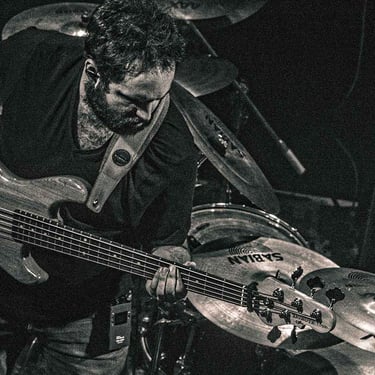 Gros plan sur une guitare électrique vibrant au son du concert, capté par Thomas Bordas.