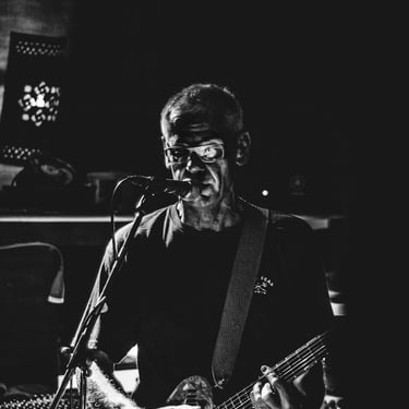Musicien à la guitare sous les projecteurs, instant immortalisé par Thomas Bordas, photographe et vidéaste à Pau.