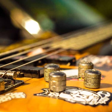 Gros plan sur une guitare vibrante, capturé par Thomas Bordas.