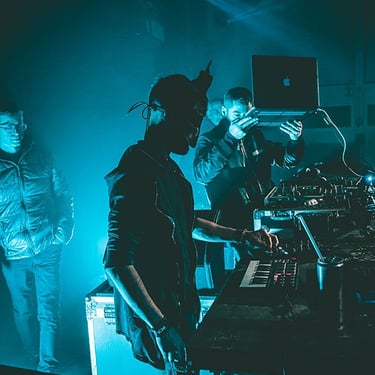 DJ concentré sur ses platines, entouré de jeux de lumière dynamiques, capturé en photo et vidéo par Thomas Bordas.