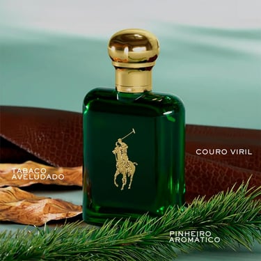 Polo Ralph Lauren green cologne bottle with gold cap near leather, tobacco leaves, and pine.