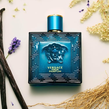 Versace Eros Parfum blue bottle surrounded by lavender, vanilla beans, and woody notes.
