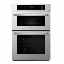 A stainless steel double wall oven features a digital control panel above, with two spacious black glass doors and sleek hand