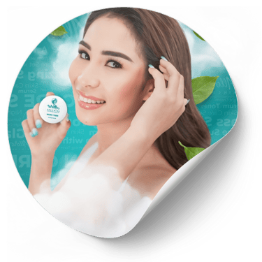 Person holds skincare cream while pulling hair back, surrounded by a blue backdrop with green leaves.