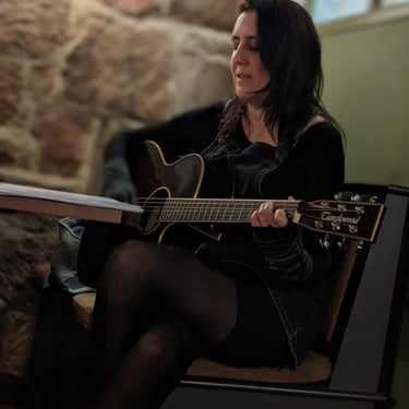 Singer Songwriter Angie Jean playing acoustic guitar