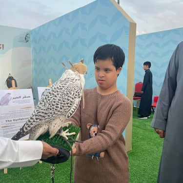 طفل يحمل صقراً
