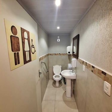 Banheiro acessível com barras de apoio no Studio Brothers em Porto Alegre