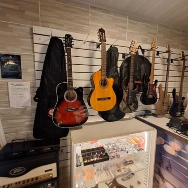 Guitarras penduradas e vitrine de acessórios na loja do Studio Brothers em Porto Alegre