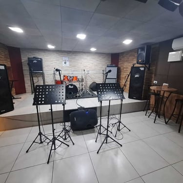 Palco com bateria amplificadores e estantes de partitura no Studio Brothers em Porto Alegre