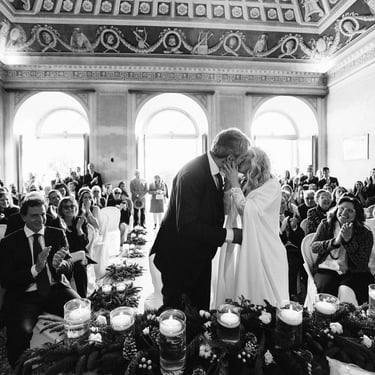 Il bacio degli sposi dopo il si durante la cerimonia di nozze civile. Gli invitati applaudono divertiti ed emozionati