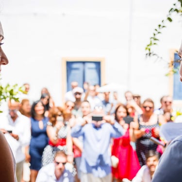 Durante il rito civile di matrimonio la sposa osserva la tensione dello sposo, davanti a loro gli invitati