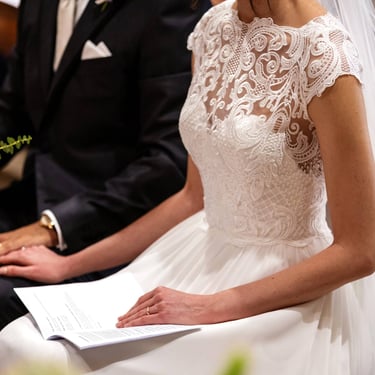 In Chiesa durante la cerimonia di matrimonio la sposa e lo sposo si sfiorano dolcemente le mani